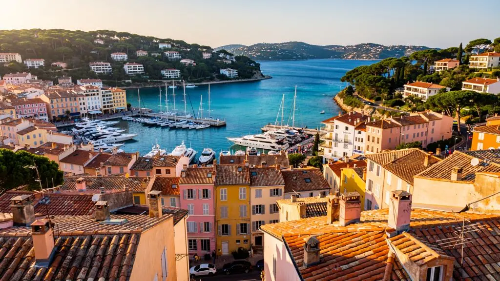 Panoramic elevated view of Saint-Tropez harbor and old town with pastel buildings, luxury yachts, and Mediterranean coastline Panoramic elevated view of Saint-Tropez harbor and old town with pastel buildings, luxury yachts, and Mediterranean coastline